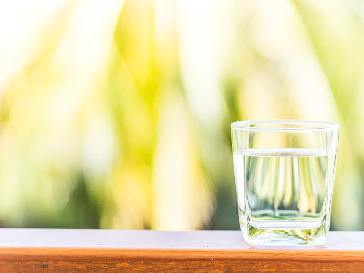 Vaso de agua sobre una mesa al aire libre