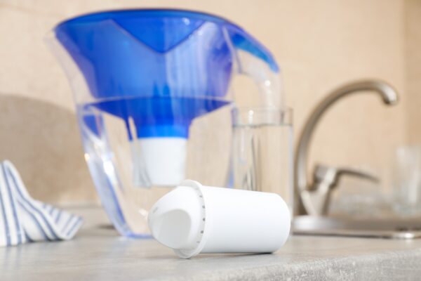 Jarra con filtro de agua y cartucho de recambio sobre la encimera de la cocina
